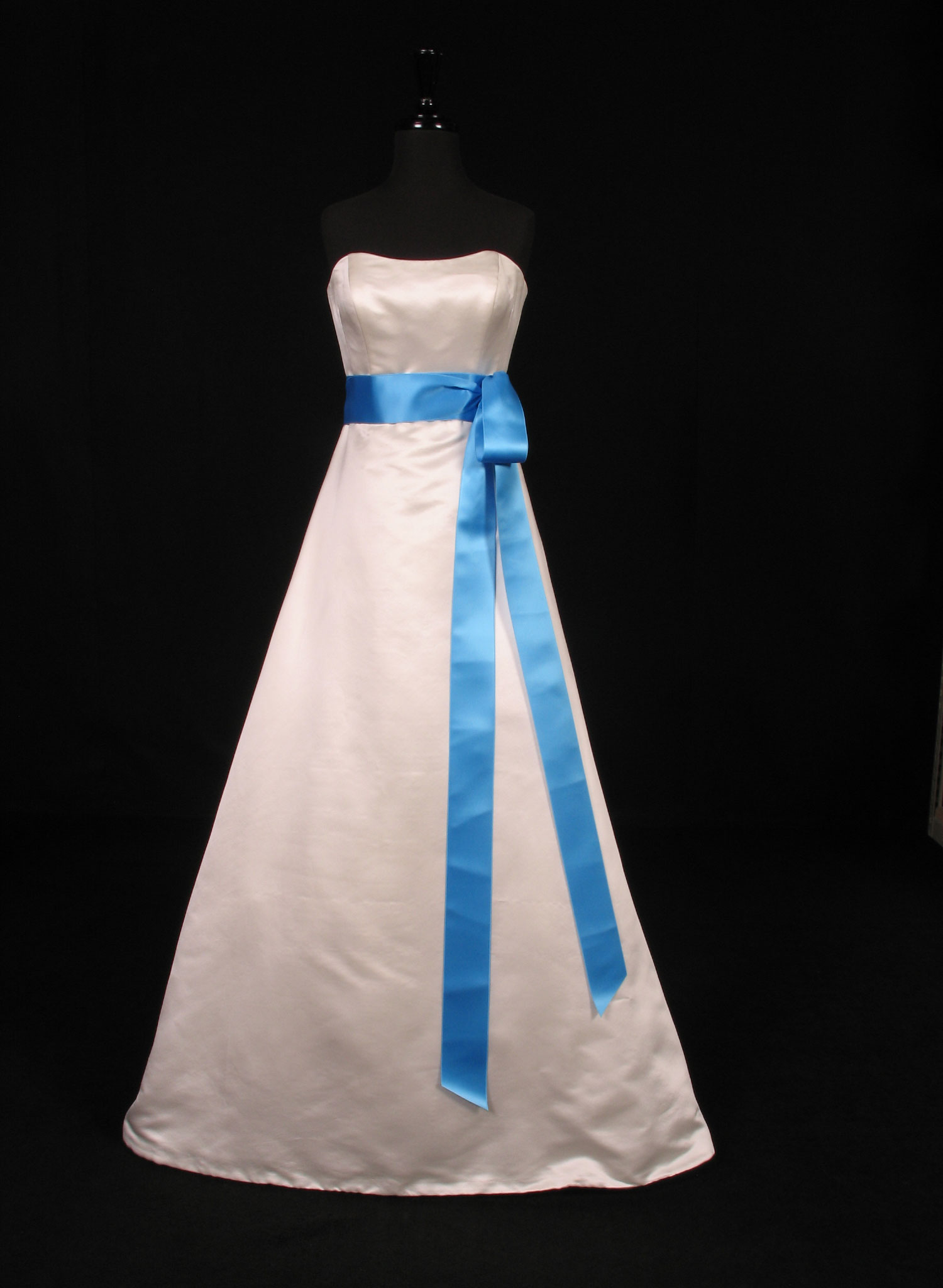 Wedding dress on a form with a ocean satin ribbon sash