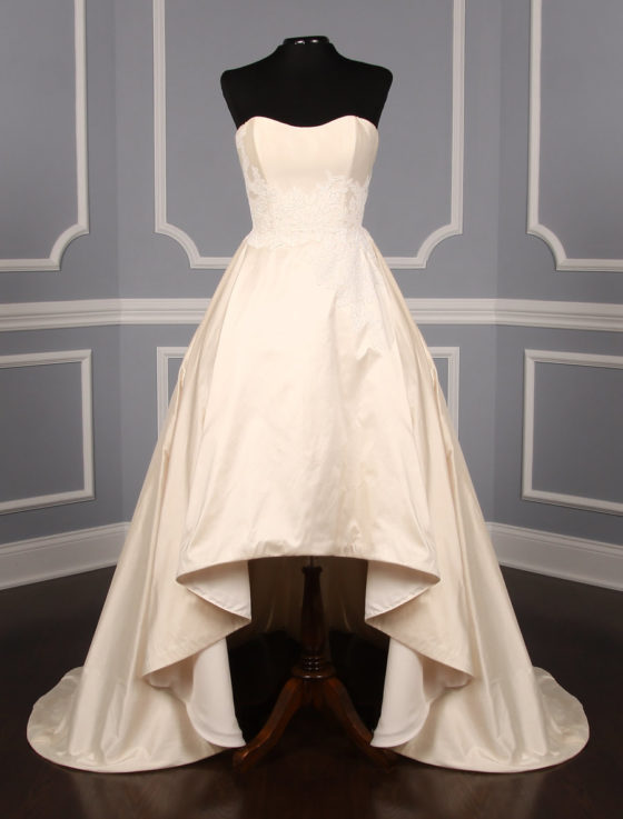 This Romona Keveza Legends L7130 wedding dress is Brand New!  It is made from beautiful silk shantung taffeta with lace appliques.  The ivory color is a vanilla shade, a bit of a warmer ivory.  This Romona Keveza Legends wedding dress is strapless with a ballgown silhouette, a high low hemline and a chapel train.  Side seam pockets are hidden in the skirt and are perfect for holding a few tissues or your lipstick.  You will definitely 'wow' your guests as you walk down the aisle in this stunning couture creation!